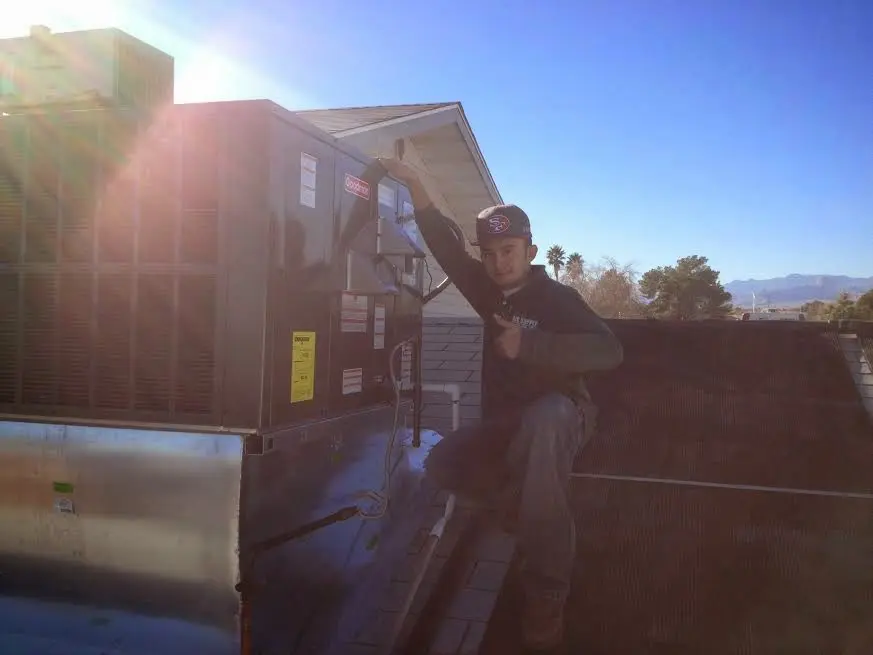 HVAC technician performing Air Duct Repair on a rooftop unit in Albany